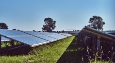 black solar panels on green grass field under blue sky during daytime