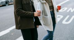 Couple walking on street with coffee cups