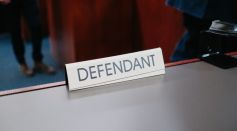 a desk with a sign on it that says defendant