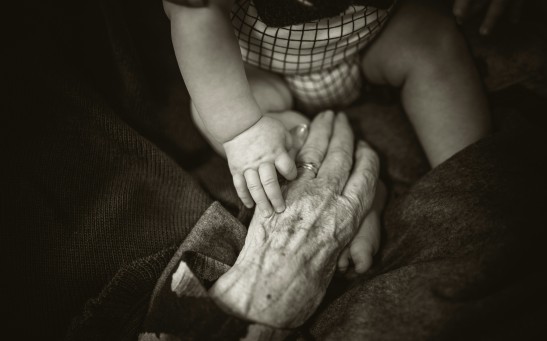 Elderly Person Holding Baby's Hands