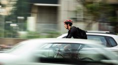 man riding bicycle near car