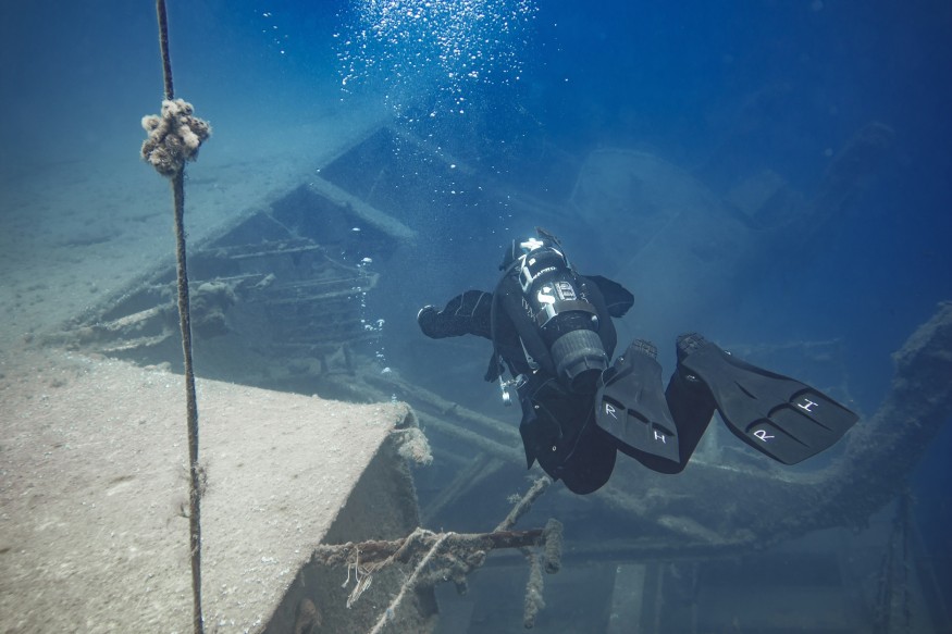 Person Diving Deep in the Ocean