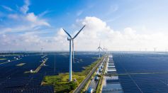 Solar power stations in plain areas, wind turbines in the distance. Yancheng City, Jiangsu Province, China. - stock photo